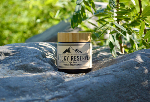 Jar labeled 'Rocky Reserve' on a rock with greenery in the background