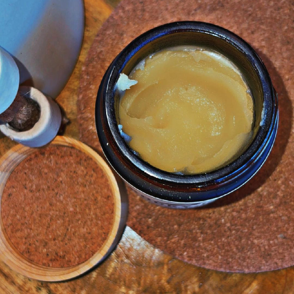 Small container of yellow substance on a wooden surface