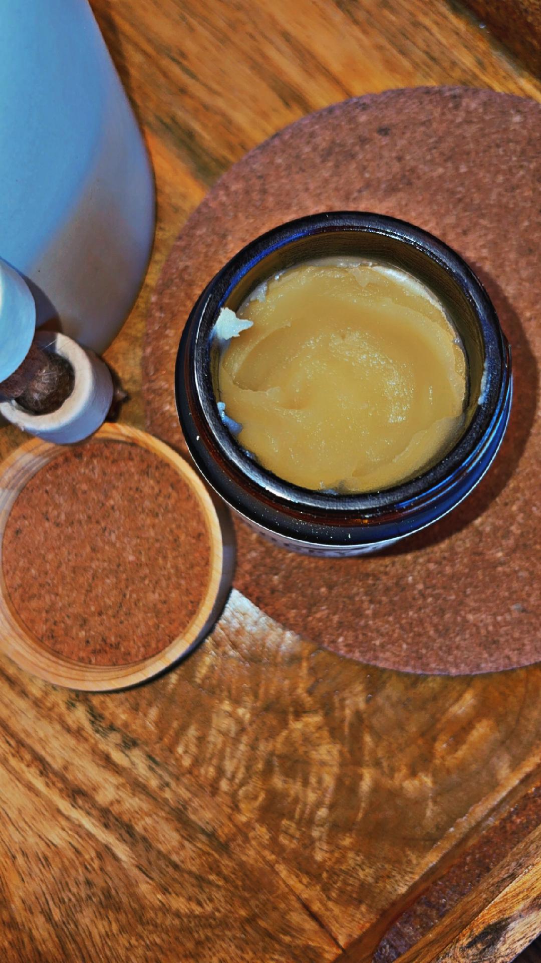 Small container of yellow substance on a wooden surface