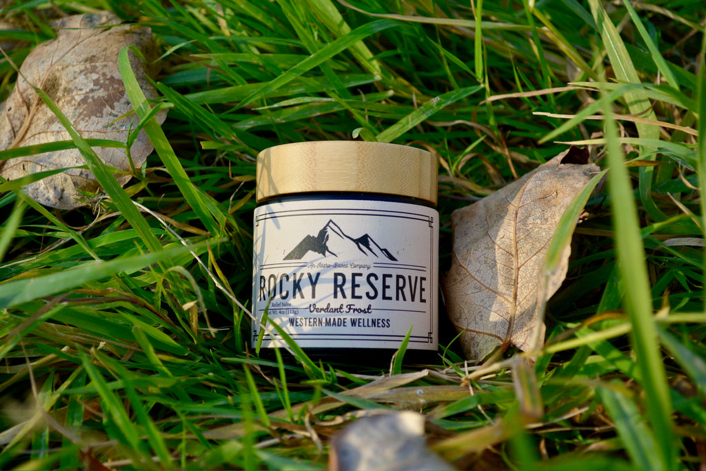 Jar labeled 'Rocky Reserve' on grass with mountains on label