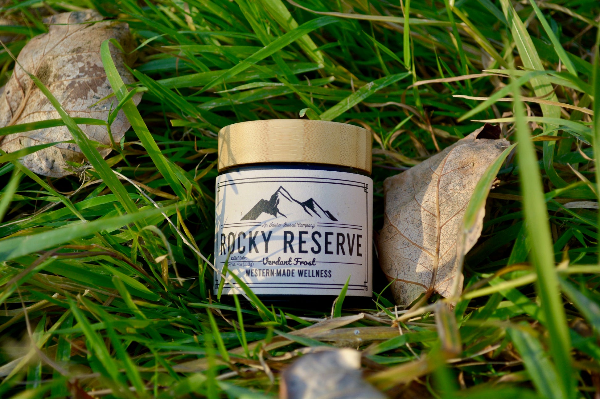 Jar labeled 'Rocky Reserve' on grass with mountains on label